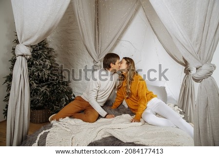couple in love kissing while sitting on the bed