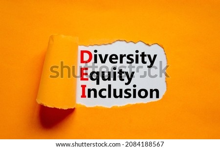Diversity, equity, inclusion DEI symbol. Words DEI, diversity, equity, inclusion appearing behind torn orange paper. Orange background. Business, diversity, equity, inclusion concept, copy space. Royalty-Free Stock Photo #2084188567