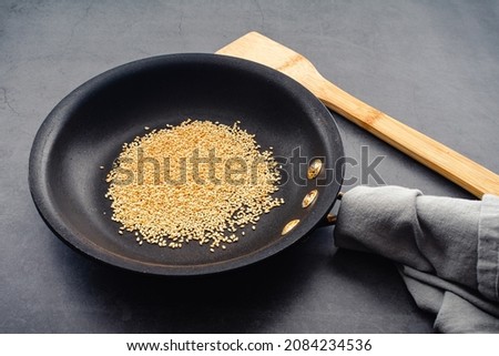 Toasted Sesame Seeds in a Small Skillet: Sesame seeds that have been toasted to a golden brown color