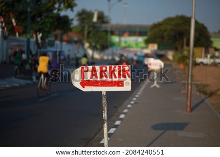 Red parking signage in bahasa Indonesia. Parkir signage with blurry background, at alun-alun kidul Yogyakarta.