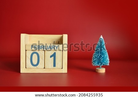 February 1, Calendar design with Christmas tree on red table background.