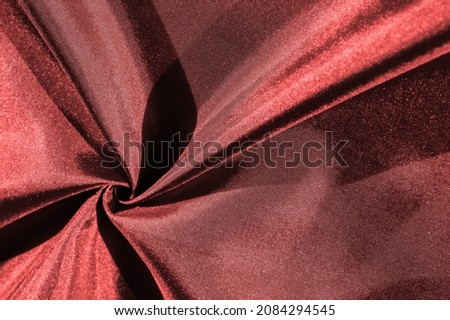 ruby red silk fabric, metallic shades of fabric, shiny red metallic background for decorative design, decor element, wallpaper. texture pattern