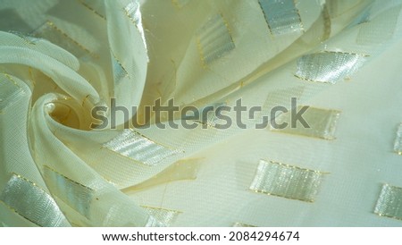 silk fabric with metal square inserts of platinum, bordered by a gold line, ivory pastel, textured background, patterned card