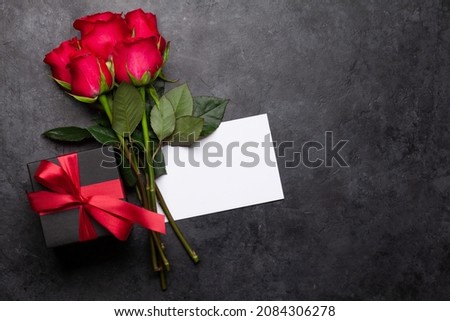 Valentines day greeting card with red rose flowers bouquet and gift box on stone table. Top view flat lay with space for your greetings Royalty-Free Stock Photo #2084306278