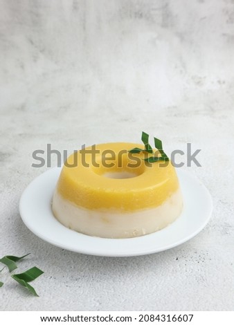 Kue talam labu kuning or Talam cake is an Indonesian sweet dessert. It made from tapioka and rice flour, coconut milk, and pumpkin. Selective focus.  Royalty-Free Stock Photo #2084316607