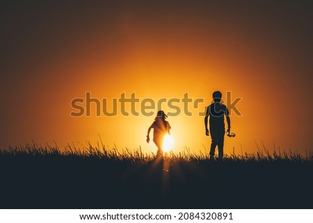 Kids are playing on field at sunset