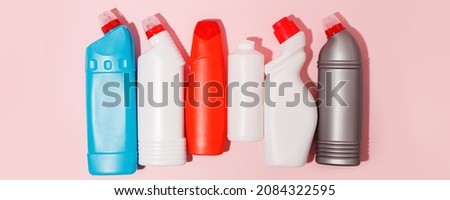 Chemical poisoned cleaning supplies bottles isolated on pink pastel background. Hard shadow, trendy shot, copy space for your adds, cleaning service flyer, coupon, banner