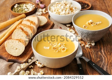 Bowls with tasty popcorn soup on table