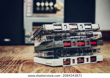 Old cassette tapes and hifi audio player at background. Royalty-Free Stock Photo #2084343871