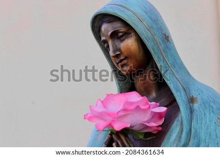 The Virgin Mary holding a rose  Royalty-Free Stock Photo #2084361634