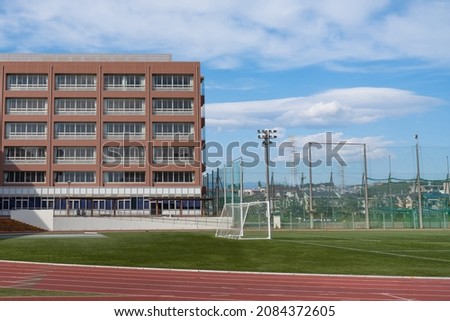 School building and soccer ground Royalty-Free Stock Photo #2084372605