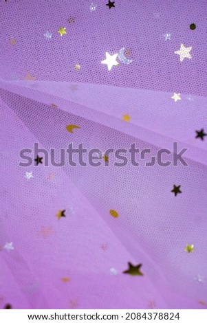 Light pink Crumpled festive tulle fabric (pink, purple, delicate) with sequins in the form of stars drapes beautifully. texture of wedding clothes, veil, dress, skirt.