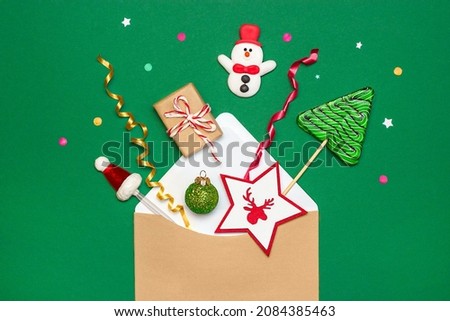 envelope with christmas decorations on a green background