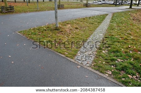 abbreviation of rectangularly connected park paths. so that people walking in the shortest possible way do not damage the lawn and do not form mud, they have a narrow path newly paved Royalty-Free Stock Photo #2084387458