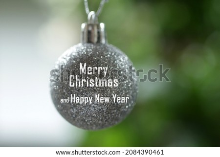 Merry Christmas and Happy New Year. Christmas and New Year card greeting concept on white silver Christmas ball ornament on light green blur background. Christmas backgrounds.