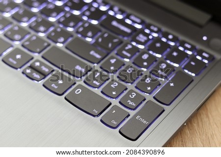 Backlit keyboard, gray laptop with focus on the ENTER button Royalty-Free Stock Photo #2084390896