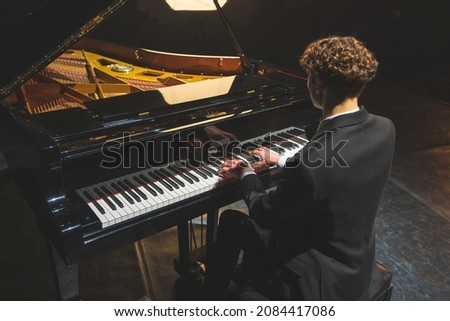 Professional pianist performing a piece on a grand piano