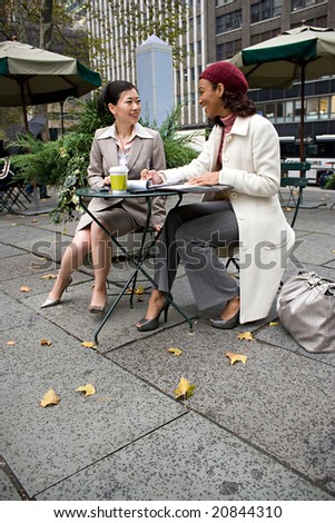 Two business women having a casual meeting in the city.