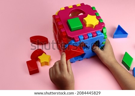 child plays with plastic bright toys, hands close-up. Early learning, educational games