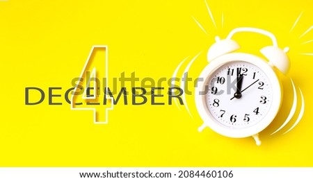 December 4th. Day 4 of month, Calendar date. White alarm clock with calendar day on yellow background. Minimalistic concept of time, deadline. Winter month, day of the year concept