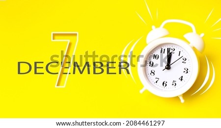 December 7th. Day 7 of month, Calendar date. White alarm clock with calendar day on yellow background. Minimalistic concept of time, deadline. Winter month, day of the year concept