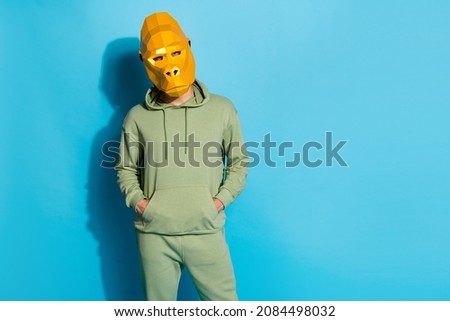 Photo of serious charismatic guy dressed animal mask arms hands pockets empty space isolated blue color background