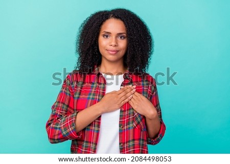 Photo of young attractive afro lady arms on heart appreciate honest promise isolated over teal color background