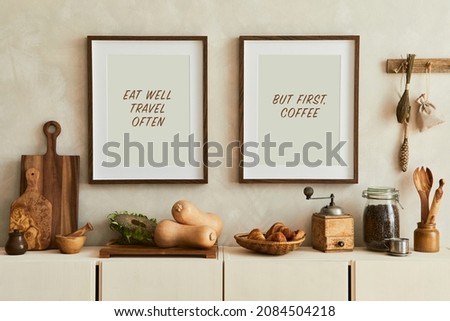 Stylish and modern kitchen interior composition with mock up poster frames, beige wooden sideboard, vegetables and retro inspired accessories. Template. Autumn vibes.
