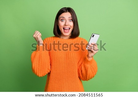 Portrait of attractive trendy cheerful girl using device rejoicing feedback follow isolated over bright green color background