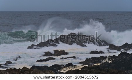 Strong waves breaking on the rocky coast of Vancouver Island viewed from Wild Pacific Trail in Ucluelet, British Columbia, Canada with foam in the water on cloudy day in autumn season. Royalty-Free Stock Photo #2084515672
