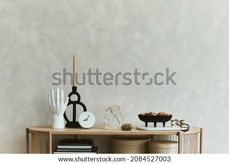 Stylish composition of personal accessories on the console in the living room. Sculpture, candlectick, minerals and tray. Copy space. Template.