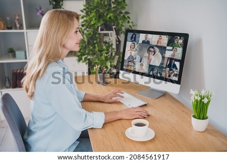 Photo of charming sweet age woman dressed blue shirt sitting table having video conference modern gadget smiling indoors home room