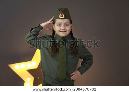 Portrait of little girl in green uniform. Happy veteran day celebration. Memorial day respect and victory concept. Veterans Day. Holiday and school uniform