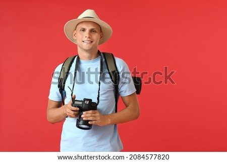 Male tourist on color background
