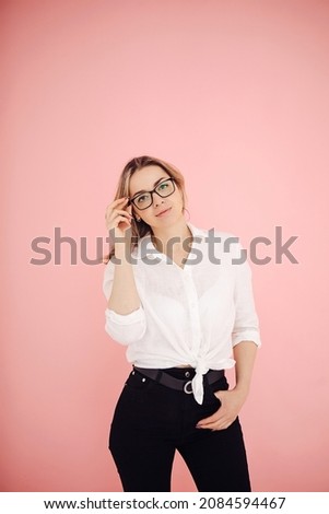 a bright cute girl with glasses on a pink background and a white shirt
