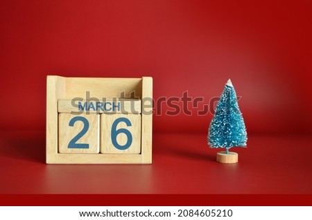 March 26, Calendar design with Christmas tree on red table background.