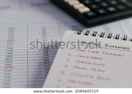 Monthly expenses list on notepad. Selective focus. 