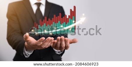 Businessman holding graph growth and increase of chart positive indicators in his business.Investment up concept.analyzing sales data and economic,strategy and planning, Digital marketing and stock