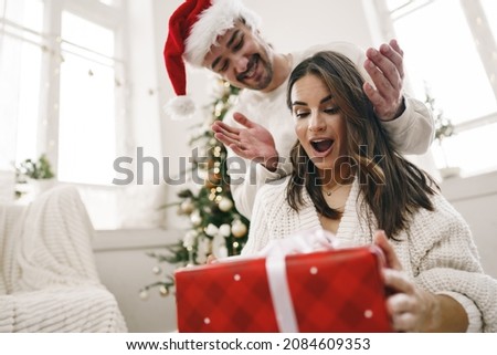 Young cheerful couple in love with present for Christmas