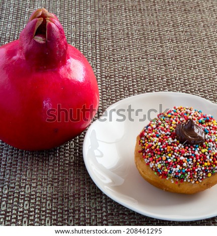 Colorful donut with chocolate cream and  pomegranate for Jewish Holiday. 