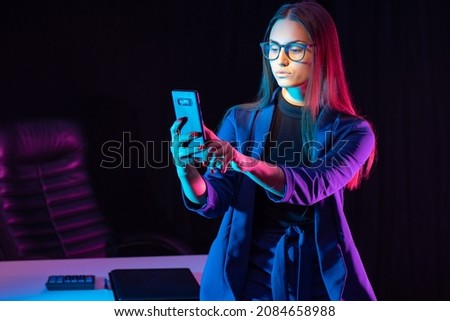 Woman telephone. Business woman takes pictures on phone. Business woman in stylish blue suit. Young girl next to workplace. Office worker takes selfie on phone. Lady typing message into cellphone