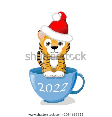 Сute little tiger in a Santa hat is sitting in a blue cup. Cartoon New Year's clip art.