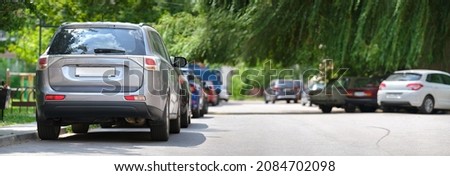 City traffic with cars parked in line on street side. Vehicle parking concept. Royalty-Free Stock Photo #2084702098