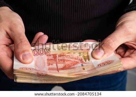Close-up men's hands hold a wad of Russian money five thousand bills. Royalty-Free Stock Photo #2084705134