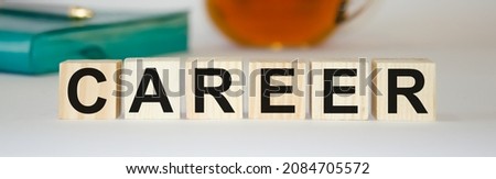 the word career written on wooden cubes on the back of a notepad and tea. High quality photo
