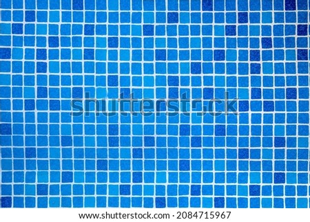 Bottom of the pool water texture. Sun reflection on the blue clear water ripples of pool with tile bottom. 