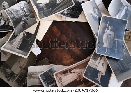 on an old wooden table there are old photographs of 1950-1960, , concept of family tree, genealogy, childhood memories, connection with ancestors Royalty-Free Stock Photo #2084717866