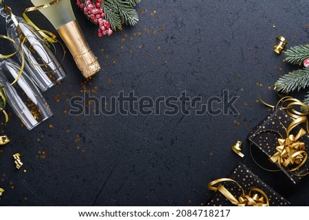 Holiday gift box or present with ribbon, golden confetti and gold baubles on black background. Magic christmas greeting card. Christmas Decoration. Border design. Mock up. Top view.