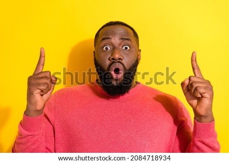 Portrait of impressed funny person pouted lips direct fingers up empty space isolated on yellow color background