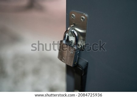 Padlock on gate of small gray container closeup . High quality photo Royalty-Free Stock Photo #2084725936